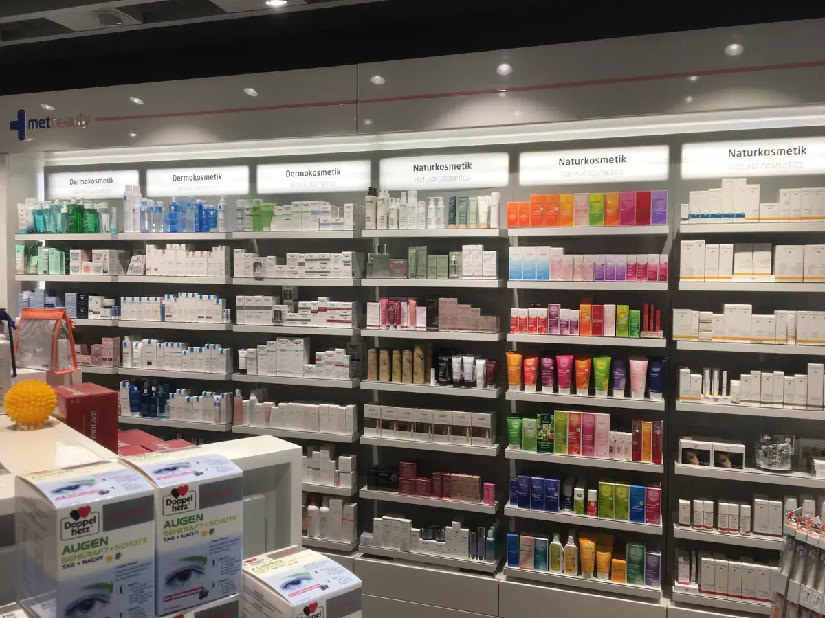 Backlit pharmacy dermocosmetics wall with branded shelf-edge signage and organized skincare product bays